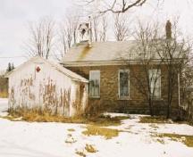 Vue de l'extérieur de l'ancienne école de rang de Mount Pleasant, qui montre sa petite taille, sa forme et sa volumétrie simples, 2005.; Department of Public Works and Government Services / Ministère des Travaux publics et services gouvernementaux, Alice Da Silva, 2005.