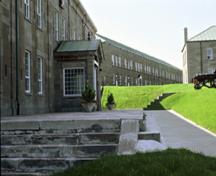 Vue de côté de l'État-major du Royal 22e Régiment, ancien hôpital, bâtiment 1 démontrant les détails d’inspiration néoclassique qui ornent l’entrée principale de l’édifice, 1993.; Parks Canada Agency / Agence Parcs Canada, C. Rodriguez, 1993.
