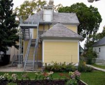 Vue générale de l'arrière de la Maison Gabrielle-Roy montrant les éléments paysagers subsistant depuis l’époque où la famille Roy étaient propriétaire, y compris quelques arbres centenaires, 2008.; Parks Canada Agency / Agence Parcs Canada, N. Clerk, 2008.
