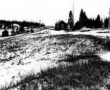 Vue générale du lieu historique national du Canada du Site-de-la-Rivière-Pic, montrant une partie de l’ancien site du fort Pic et un petit bâtiment qui contient un puits de l'occupation par la Compagnie de la Baie d'Hudson.; Parks Canada Agency/Agence Parcs Canada