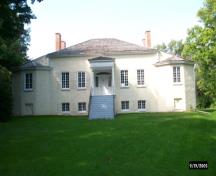 General view showing the rectangular massing of the single storey main block with balanced subsidiary wings set high on a foundation.; Parks Canada Agency / Agence Parcs Canada