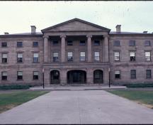 General view showing the symmetrical three-storey massing of the building with its central section, balanced wings and shallow hipped roof.; Parks Canada Agency / Agence Parcs Canada