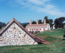 Vue générale du lieu historique national du Canada du Fort-Anne montrant des éléments survivants du fort original, par example: la poudrière (gauche) et le quartier des officiers (droite), 1977.; Parks Canada Agency / Agence Parcs Canada, T. Grant, 1977.
