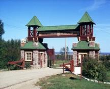Vue générale du du Bâtiment de l’entrée est du Centre d'Inscription de l'Entrée Est du Parc du Mont-Riding qui montre sa conception en un pont à poutre triangulée au-dessus de la route, 1973; Parks Canada Agency / Agence Parcs Canada, P. McCloskey, 1973