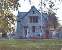 Front facade of the Gatehouse Lodge, showing the exterior stonework including the irregular rubble walling with rustic Haddington Island stone corner quoins, 2000.; Department of National Defence / Ministère de la Défense nationale, 2000.