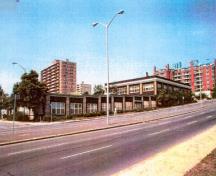 Vue générale de l'Ancien édifice de la CCN montrant la volumétrie rectiligne, sur un et deux niveaux, de ce long édifice bas, 1995.; Public Works Government Services Canada \ Travaux publics et Services gouvernementaux Canada, 1995.