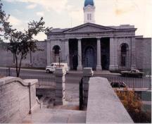Front facade of the North Lodge building showing the building’s simple neo-classical form and massing, which consist of a symmetrical rectilinear plan.; Parks Canada Agency / Agence Parcs Canada, n.d.