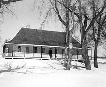 Façade de la grande maison, qui montre la véranda qui court sur trois côtés du corps principal, 1989.; Parks Canada Agency / Agence Parcs Canada, 1989.