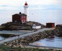 Vue du Phare de Fisgard, qui montre sa volumétrie composée de deux formes simples, soit une tour cylindrique et une maison rectangulaire attenante.; Ian Doull / Agence Parcs Canada, 2010 - Ian Doull / Parks Canada Agency, 2010