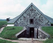 Façade de la Poudrière sud démontrant la seule porte à traverse supérieure carrée, 1994.; Parks Canada/ Parcs Canada. Jérôme, J.P, 1994.