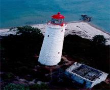 Vue aérienne du phare de l'île Chantry démontrant sa haute forme ronde légèrement fuselée qui se termine par un encorbellement légèrement saillant qui forme un balcon de veille et une base pour le lanterneau, 1990.; Canadian Coast Guard / Garde côtière canadienne, 1990.