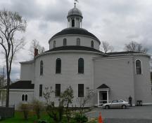 View from the street of the church and its particular shape; Parks Canada / Parcs Canada, 1984
