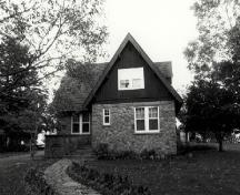 Façade de la résidence du directeur du parc, qui montre l'aile de l’avant dotée de pignons et recouverte de planches verticales, v. 1990.; Parks Canada Agency / Agence Parcs Canada, c./v.1990.