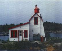 Vue de l'entrée arrière du Phare, qui montre la jonction sans interruption de la tour et de la résidence.; Agence Parcs Canada / Parks Canada Agency.