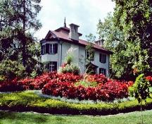 General view of Bellevue House, showing its wall construction of local limestone and the use of a white stucco wall finish, derived from the Italianate villas of British Picturesque designs, 1977.; Parks Canada Agency / Agence Parcs Canada, Mackenzie, 1977.