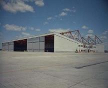 Vue du hangar 10 montrant la structure apparente composée de fermes en ailes de papillon au-dessus de la ligne de toit, v. 1962.; Department of National Defence / Ministère de la Défense nationale, circa / vers 1962.