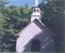View of the façade of Sainte Anne Processional Chapel, showing its solid rubblestone walls and wood shingle roofing, 1999.; Parks Canada | Parcs Canada