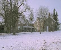 Vue générale de la maison à la ferme Thistle Ha’, qui montre sa volumétrie tripartite d’un étage et demi sous un toit à pignons, 1991.; Parcs Canada | Parks Canada