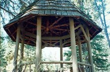 Détail du Pavillon d’observation rustique qui montre la couverture du toit en bardeaux de cèdre fendus à la main et le motif en gland taillé de la poutre centrale, 1997.; Parks Canada Agency / Agence Parcs Canada, 1997.