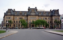 Vue générale du Bureau du Premier ministre et du Conseil privé, qui montre son style Second Empire attesté par son haut toit en mansarde ponctué de lucarnes à un et deux étages mettant  en relief la qualité tridimensionnelle de la silhouette.; Parks Canada Agency / Agence Parcs Canada.