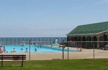 Vue du pavillon de bain et de la piscine d'eau salée, qui montre leur vue sans obstacle de la baie de Fundy.; Parks Canada Agency / Agence Parcs Canada.