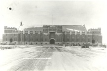 Vue générale du manège militaire Mewata, qui montre l’austère façade crénelée de pierre et de grès rouge qui se distingue par sa large entrée centrale surmontée d’un arc doucine, 1918.; Public Works Dept. | Ministère des travaux publics / Library and Archives Canada | Bibliothèque et Archives Canada / PA-053020