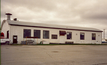 Vue générale du hangar 13, montrant des différents types de fenestration et la volumétrie rectangulaire de plain-pied coiffé d’un toit bas en arc, 1992.; Department of National Defence / ministère de la Défense nationale, 1992.
