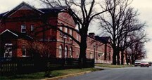 Vue en angle de la maison Wellington, montrant la façade nord et la volumétrie de deux étages de bâtiment.; Parks Canada | Parcs Canada, Canadian Forces, NS-85-6-5681