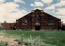 View of the Drill Hall, showing the three windows set in the symmetrical east and west façades, 1986.; Gendarmerie royale du Canada | Royal Canadian Mounted Police, 1986.